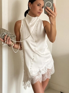 Detail of white satin sleeveless top with elegant lace hem and mock neck collar