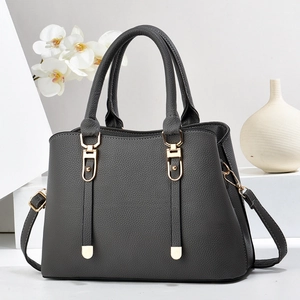 Chic dark gray lychee pattern handbag with gold hardware on a minimalist display