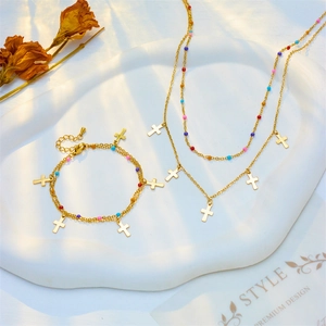 Bohemian gold stainless steel jewelry set with colorful beads and cross pendants on tray