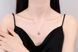 Close-up of S925 silver necklace featuring a 1 carat square moissanite halo pendant on model