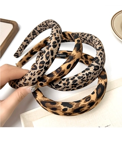 Detailed close-up of handmade leopard print wide sponge headband with artisan inner label