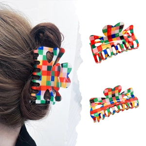 Colorful checkerboard hair claw clip with heart cutout, shown worn and in product shots