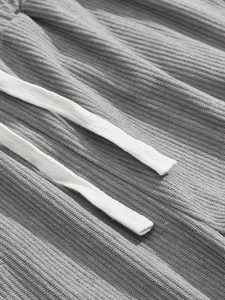 Detail shot of grey corduroy fabric texture and white drawstring on men's casual set