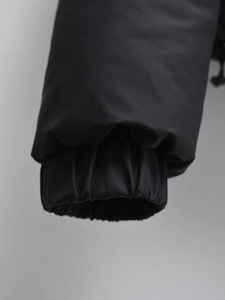 Detail of windproof elastic cuffs on black padded jacket with matte high-quality fabric