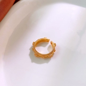 Detail of gold plated ring with ribbed texture and tiny zircon flower cluster decor