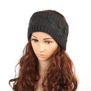 Detail showing the chunky cable knit texture and dark grey yarn of the winter headband