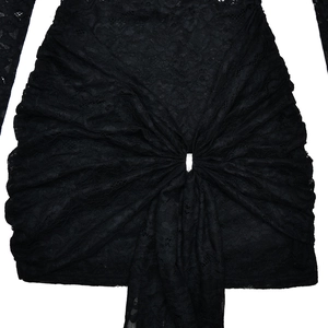 Detail of black lace dress featuring intricate floral patterns and a front knot design