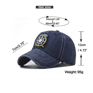 Detail showing the distressed edges and embroidered Marine logo on the navy blue cotton cap