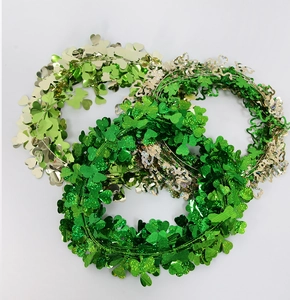 Close-up of sparkling green tinsel garlands with clover leaves for St. Patrick's Day