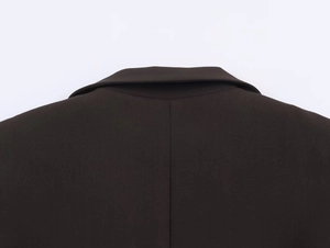 Detailed close-up of dark brown blazer collar with high-quality stitching and fabric texture