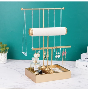 Detail of 3-tier gold jewelry stand with white velvet bars and multi-grid base