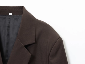 Détail du col et de l'épaule d'un blazer marron foncé avec coutures de qualité
