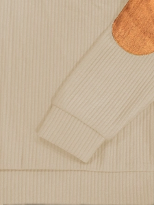 Détail macro de la manche en tricot côtelé avec patch coude marron sur sweat beige