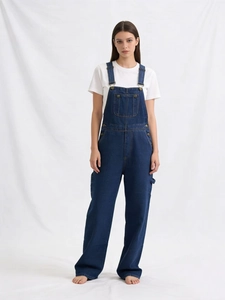 Détail de la salopette en jean bleu foncé avec boucles en métal et poches cargo