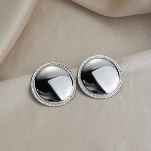 Macro shot of silver polished round stud earrings with pavé cubic zirconia edge