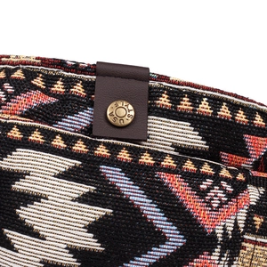 Bohemian style woven beret featuring colorful geometric patterns and leather snap closure