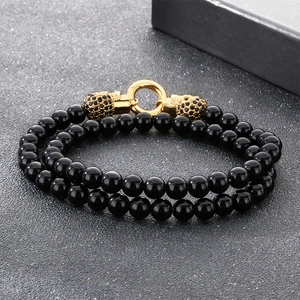 Bracelet punk en perles d'onyx noires avec têtes de mort dorées et diamants noirs