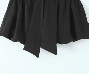 Detailed view of black knotted fabric with elegant drape and minimalist tie-up design