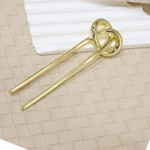 Minimalist gold alloy U-shaped hair pin with interwoven knot detail on stone background