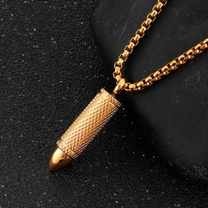 Macro detail of golden bullet pendant featuring knurled texture and polished mirror tip