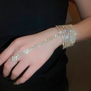 Detail of elegant gold multi-layer bracelet with sparkling rhinestones and matching ring