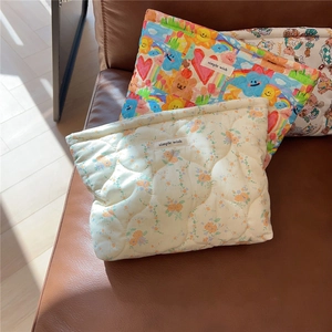 Close-up of quilted floral and bear pattern pouches with a simple wish brand label