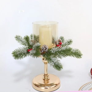Close-up of golden Christmas candle holder with glass shade and snowy pine needle decor