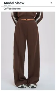 Detail view of coffee brown sports pants with white side stripes and center seam stitching