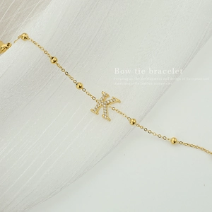 Gold titanium steel bracelet featuring a letter K pendant with zircon stone and ball charms