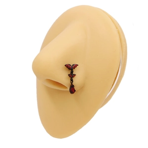 Red water-drop bat nose stud earring jewelry set on a flesh-colored silicone nose model