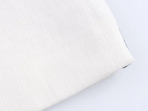 Close-up of white summer dress fabric showing high-quality twill cotton texture and weave