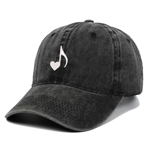 Detail showing white heart music note embroidery on washed charcoal baseball cap