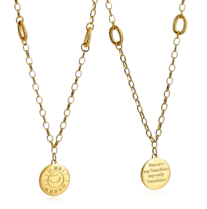 Close-up of golden sunflower pendant with double-sided smile and engraved lyrics