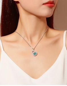 Close-up of green tanzanite gourd pendant with diamond halo on silver necklace