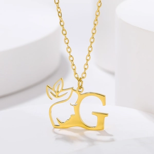 Macro shot of gold-plated pendant with hollow silhouette and letter G on white stand