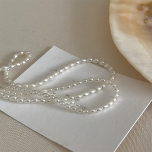Macro view of high-luster white rice-shaped freshwater pearls on a luxury necklace