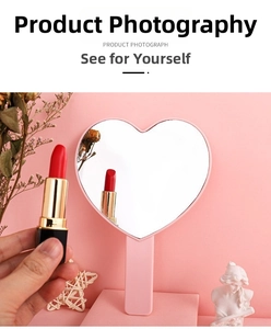 Close-up of heart-shaped pink portable makeup mirror with ergonomic long handle