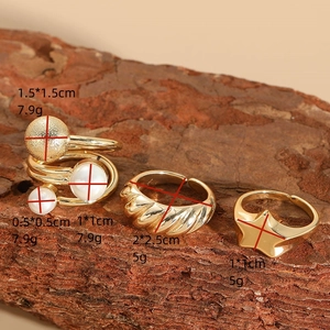 Three-piece stackable 14K gold-plated rings featuring pearls and star designs on wood bark
