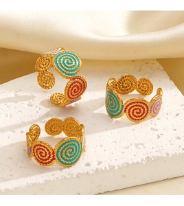 Detailed close-up of three Bohemian colorful enamel drip oil gold plated open rings on stones