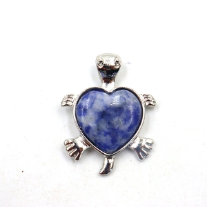 Detailopname van een zilveren schildpad hanger met een blauw hartvormig kristallen schild