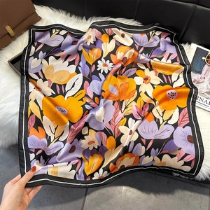 Detailed close-up of floral print square scarf with purple and orange blossoms on black