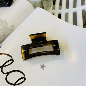 Detail of a large amber tortoiseshell hair claw clip with a transparent acrylic finish