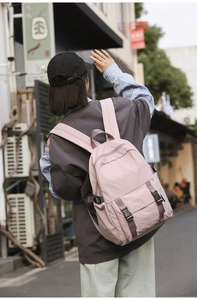 Mochila rosa impermeable de tela oxford con doble hebilla en una vista de estilo urbano
