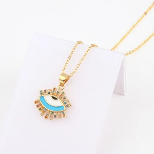 Macro detail of 18k gold evil eye heart pendant with colorful zircon and enamel