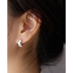Macro detail of irregular rectangular zircon inlay on s925 silver earring on model