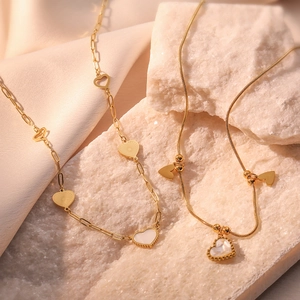 Minimalist gold plated stainless steel necklaces with shell heart pendants on stone