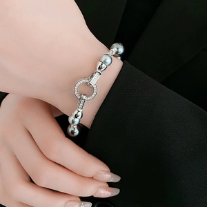 Detail shot of grey pearl bracelet with zircon paved clasp on model's wrist