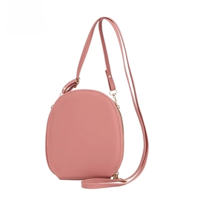 Detail of pink oval crossbody bag featuring smooth PU leather texture and gold metal zipper
