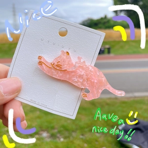 Detail of pink glittery cat-shaped hair clip made of acetate on display card