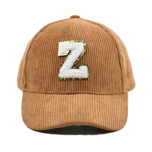 Nahaufnahme braune Cord-Baseballkappe mit weißem Plüsch-Z-Patch und goldenen Pailletten
